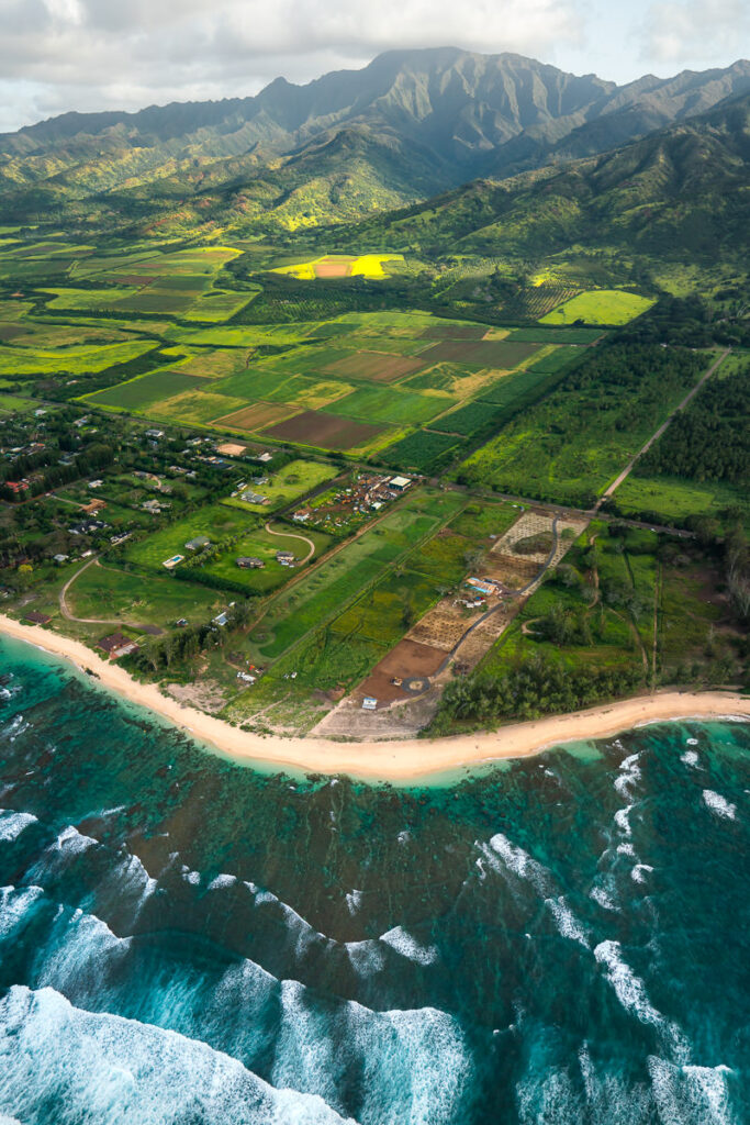 an aerial view of a beach and a tropical island.