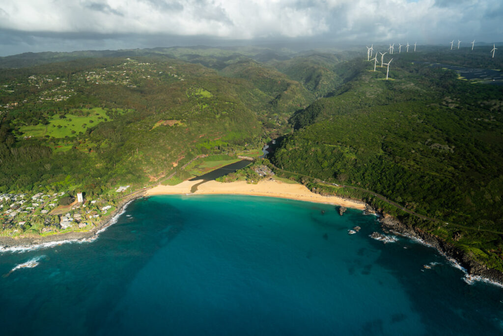 an aerial view of a beach and a wind farm.