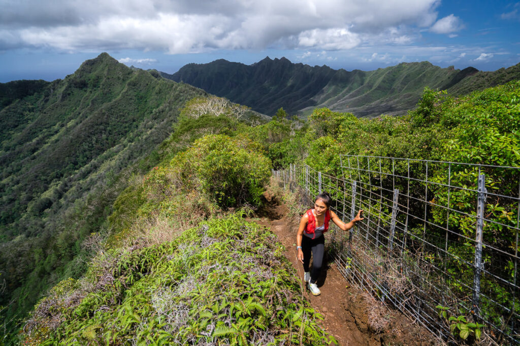 a woman hiking up a steep mountain trail.