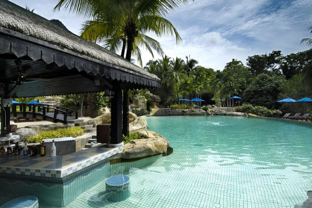 An over-water gazebo adjacent to a large pool in Malaysia.