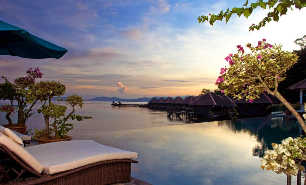 A view of a body of water at sunset from over-water bungalows in Malaysia.