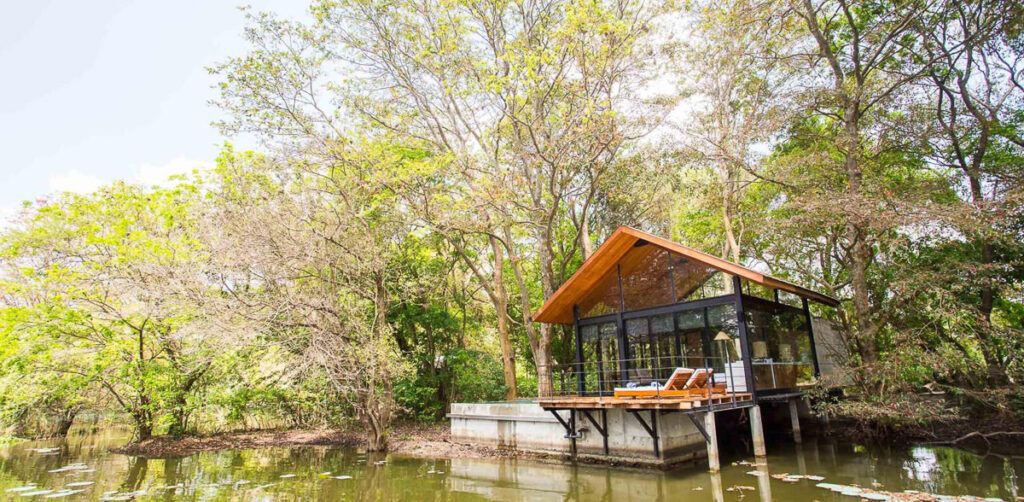 An eco-friendly boat house on a Sri Lankan lake nestled in forest.