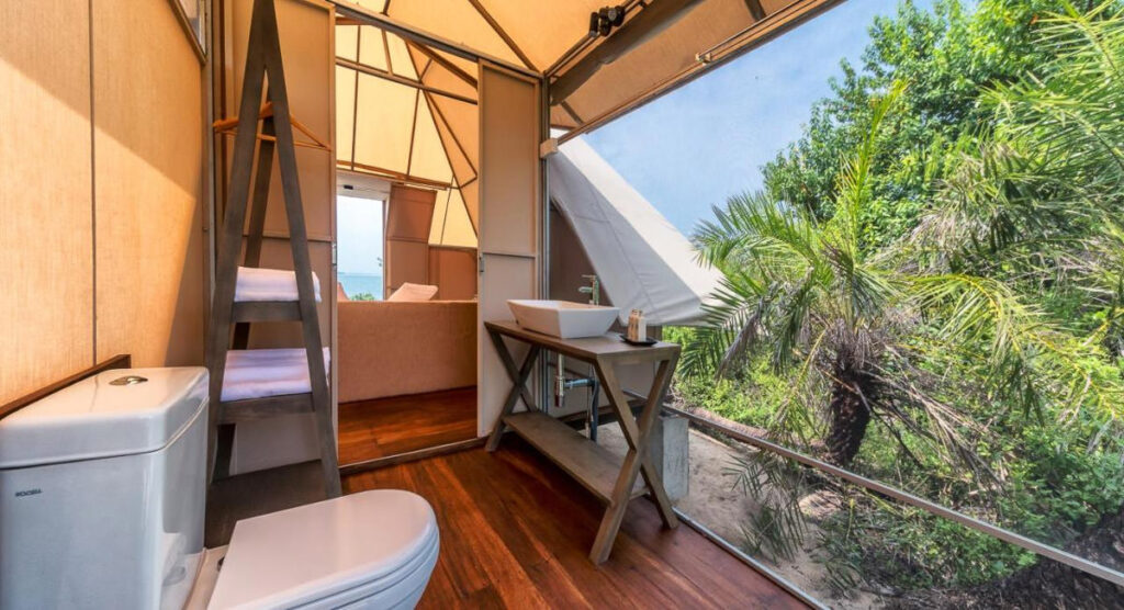 An eco-friendly bathroom in Sri Lankan lodges with a window, sink, and toilet.