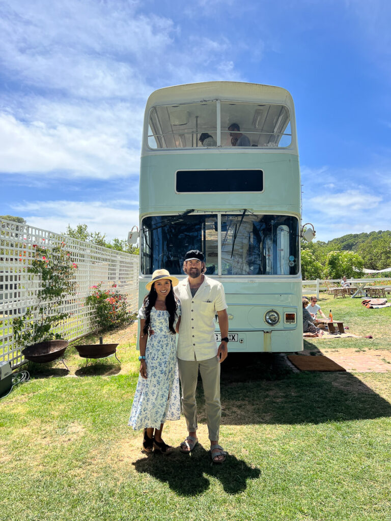 a man and a woman standing in front of a bus.