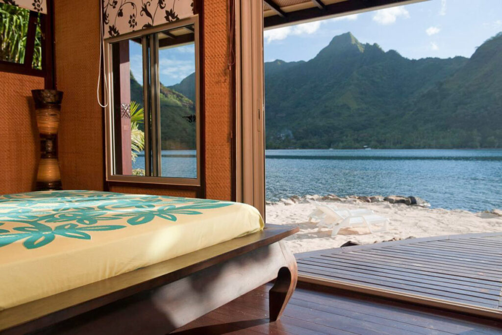 a bed in a room with a view of the ocean.