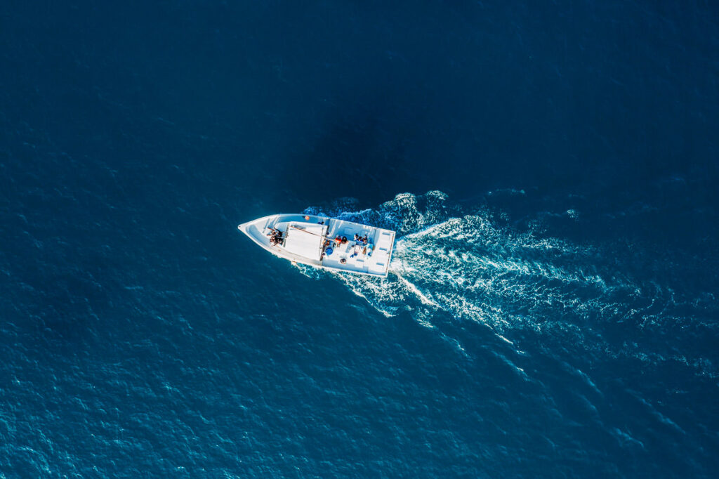 an aerial view of a small boat in the ocean.