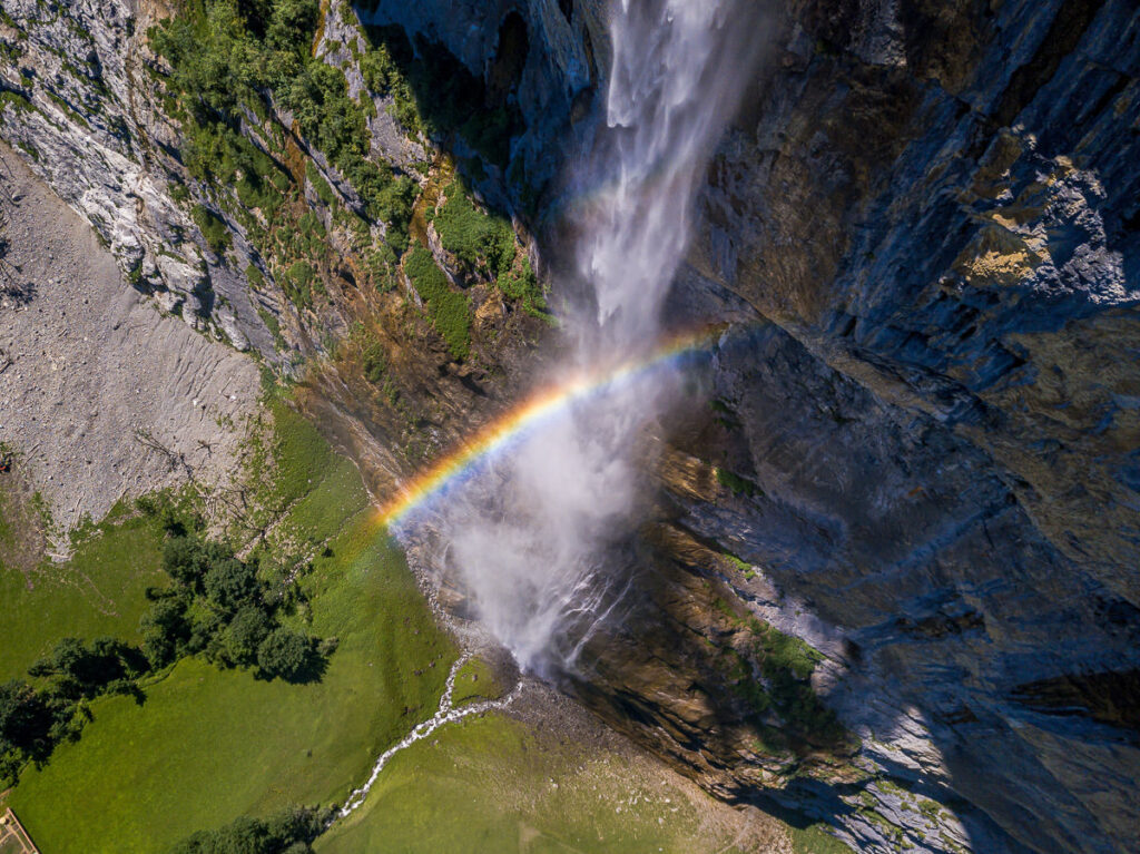 A rainbow over a waterfall in switzerland.
