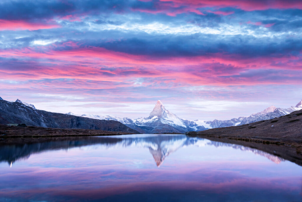 The matterhorn reflected in a lake at sunset.