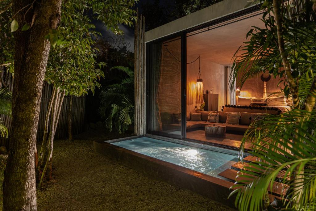 A bedroom with a hot tub in the middle of the jungle.