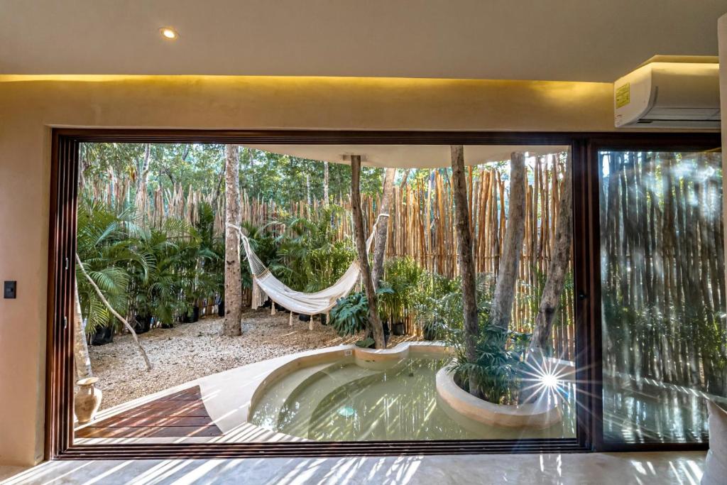 A room with a hammock and a view of the jungle.