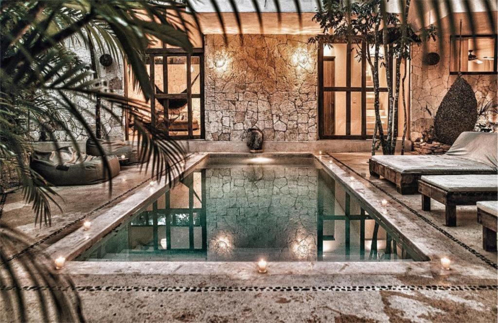 A swimming pool in a house with palm trees.