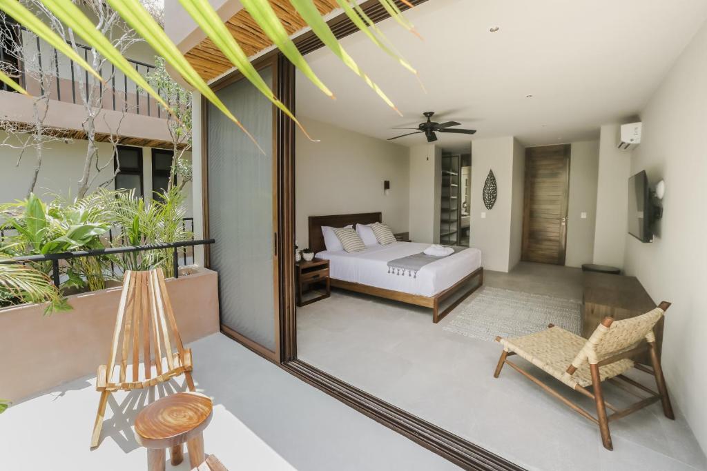 A bedroom with a balcony overlooking a tropical garden.