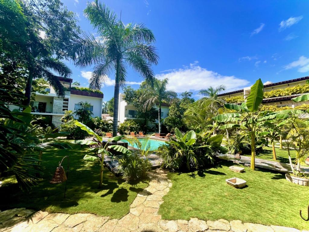 A tropical garden with a pool and trees.