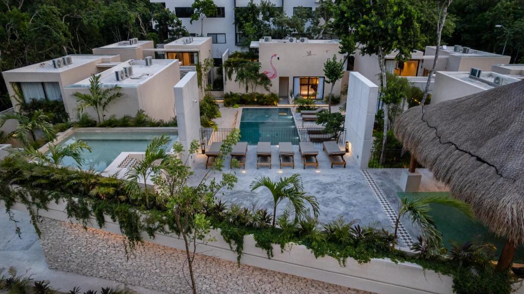 An aerial view of a house with a pool and thatched roof.