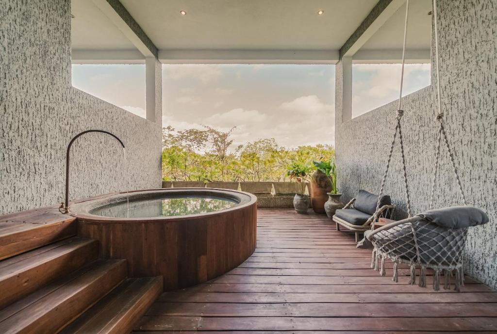 A wooden deck with a hot tub in the middle.