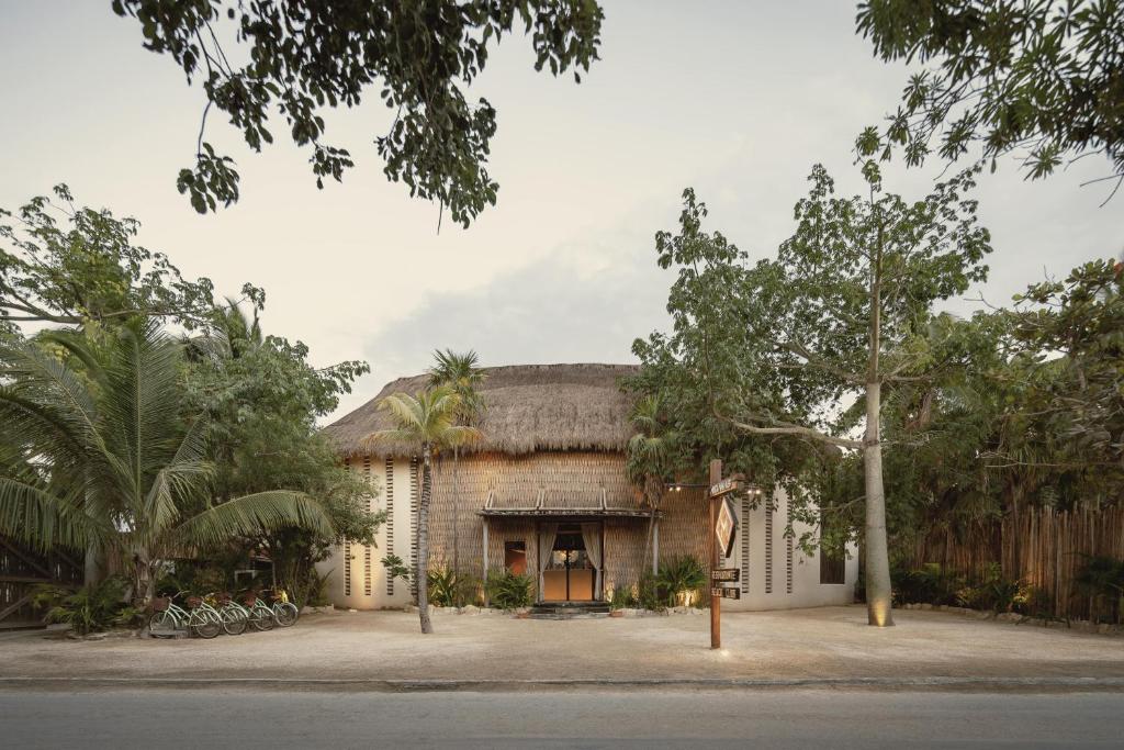 A house with a thatched roof and palm trees.