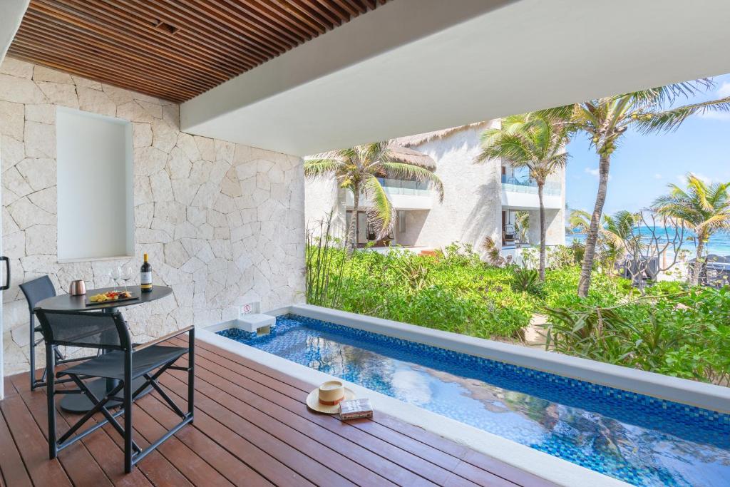 A balcony with a view of the ocean and pool.