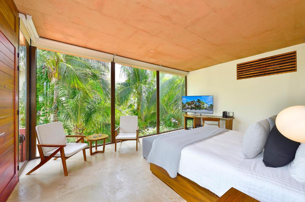 A bedroom with a bed and a view of the jungle.