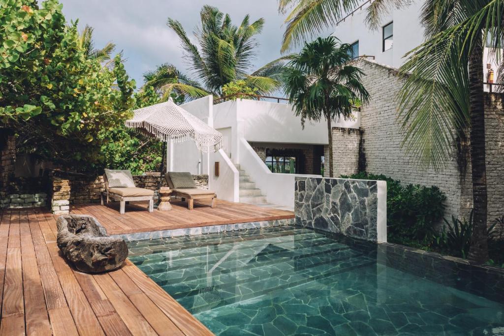 A wooden deck with a pool and lounge chairs.