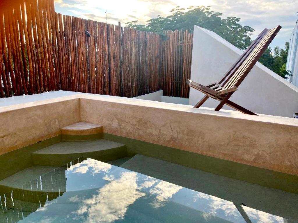 A pool with a wooden fence and a wooden chair.