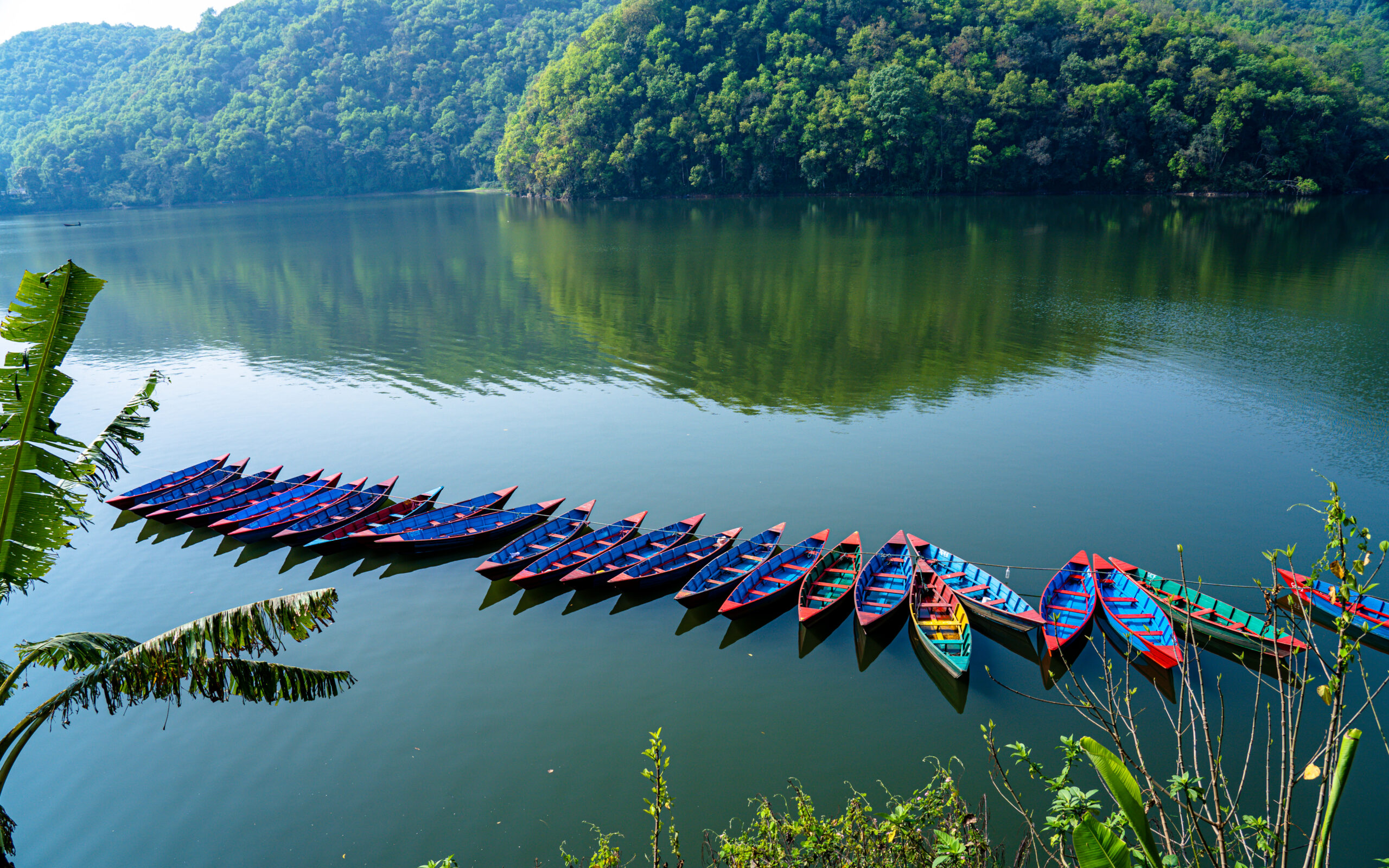 A group of canoes paddling in a body of water during the Kathmandu to Pokhara expedition.