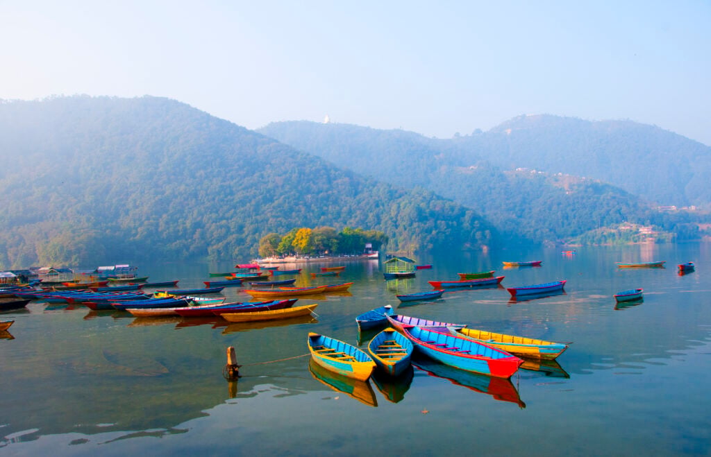 A group of boats in the body of water between Kathmandu and Pokhara.