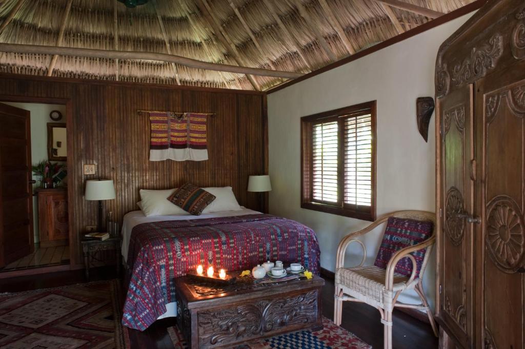 A bedroom with a thatched roof and a bed.