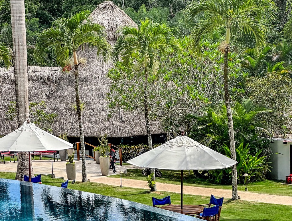 A resort with a swimming pool and thatched huts.