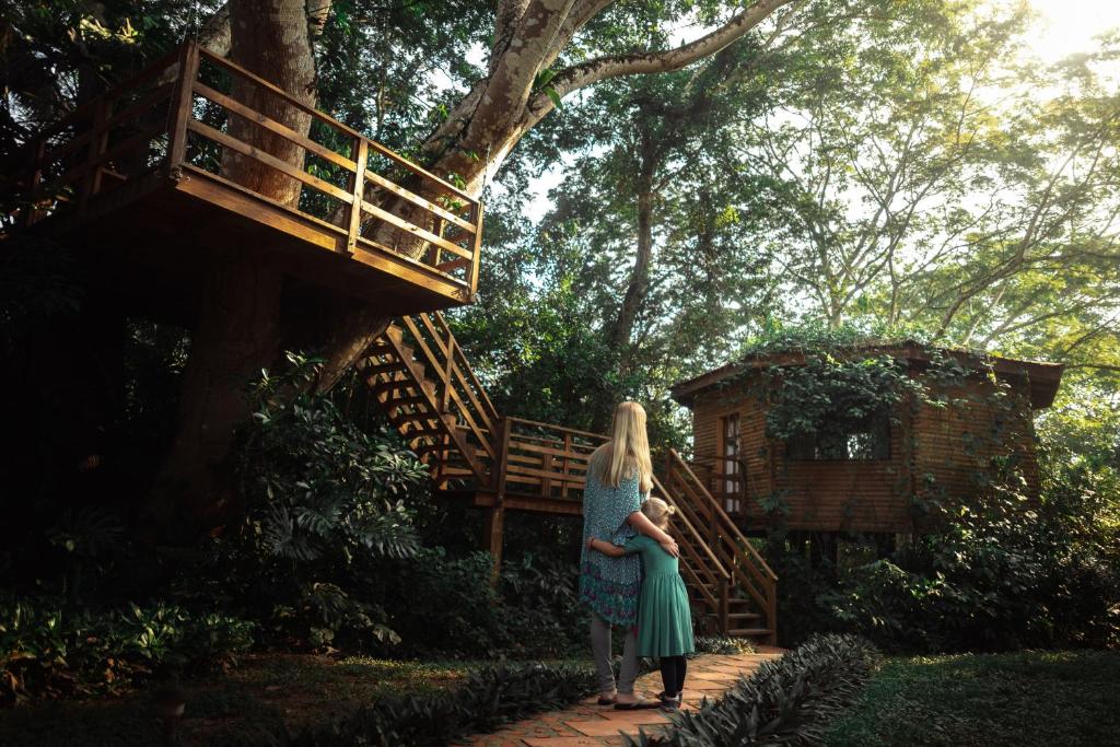 Two people standing in front of a tree house.