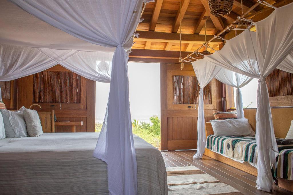 A bedroom with a canopy bed and a view of the ocean.