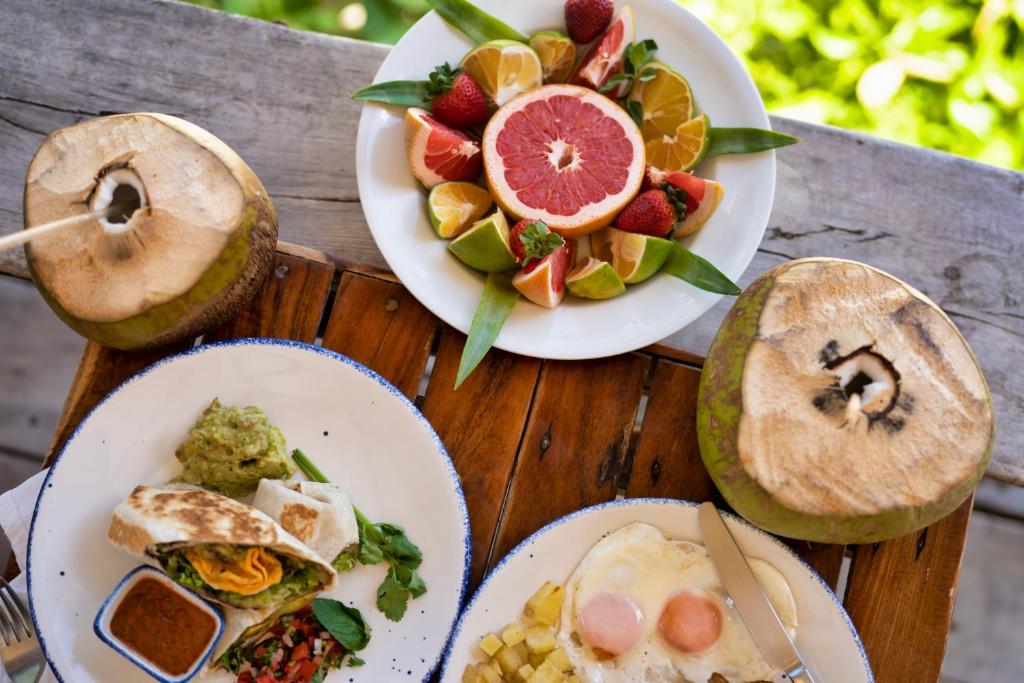 Three plates of food on a wooden table.